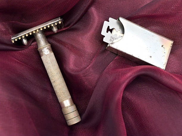 Vintage safety razor and blades on silk fabric.