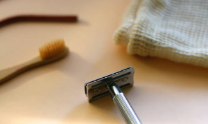 Close-up of a chrome safety razor on a neutral background.