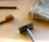 Close-up of a chrome safety razor on a neutral background.