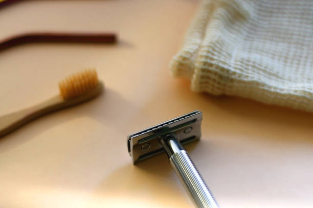 Close-up of a chrome safety razor on a neutral background.